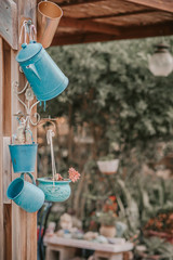 Reduce, reuse, recycle planter craft ideas. Second-hand kettles, saucepans, small bucket and old jug turn into garden flower pots. Recycled garden design and low-waste lifestyle. Vintage style.