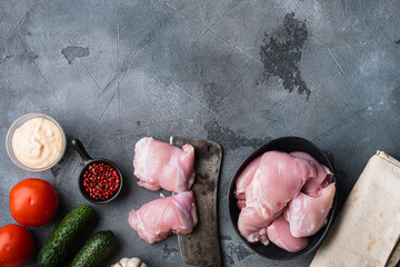 Raw ingredients, chicken thighs on grey backgroundtop viewwith space for text