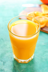 Glass of fresh orange juice on table
