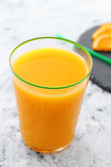 Glass of fresh orange juice on table