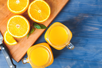 Mason jars of fresh orange juice on table