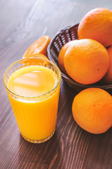 Glass of fresh orange juice on table