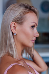 Close shot of rich luxury woman in dress  hand and ear wearing earings and ring on finger. 
