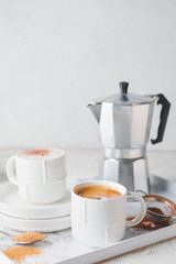 Tray with cups of hot coffee on table