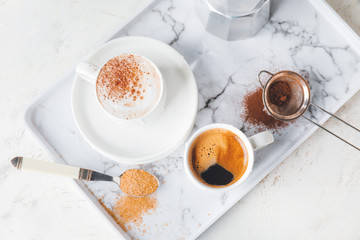 Tray with cups of hot coffee on table