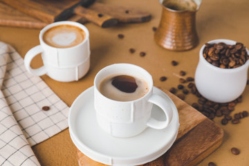 Cups of hot coffee on table