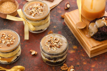 Delicious cupcakes in jars on color background