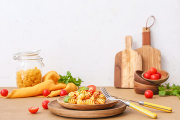 Plate with tasty pasta and chicken on table