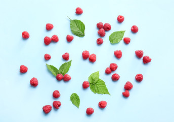 Tasty ripe raspberries on color background