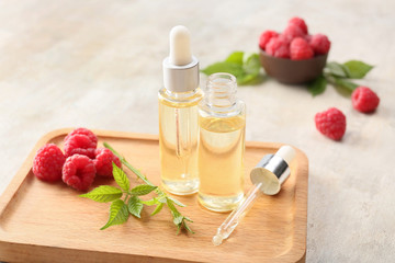 Obraz na płótnie Canvas Bottles of raspberry essential oil on table