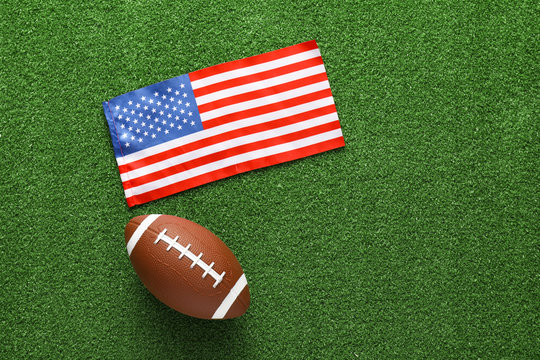 Rugby ball with national flag of USA on green grass - Powered by Adobe