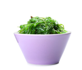 Bowl with tasty seaweed salad on white background