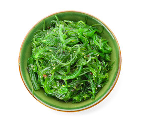 Bowl with tasty seaweed salad on white background