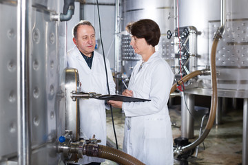 Wine maker shows to expert equipment at winery
