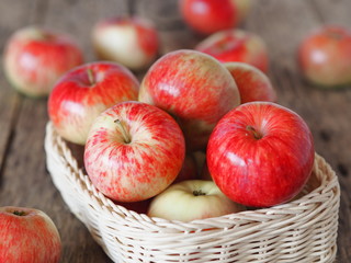 Agricultural apple background. Red early ripe apples on a wooden background.