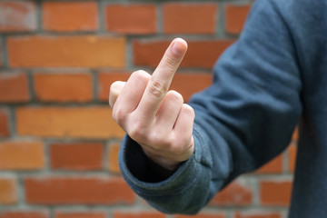 The hand of a young girl shows that the middle finger makes you fuck, bad expression, provocation...