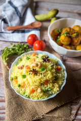 Indian style pulao or rice with vegetables arranged on a background with condiments