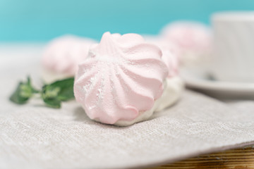 Background of sweet white marshmallows and small marshmallows on a bright trendy blue background. Sweets. dessert.