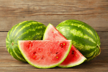 Fresh watermelon and slice on grey wooden background.