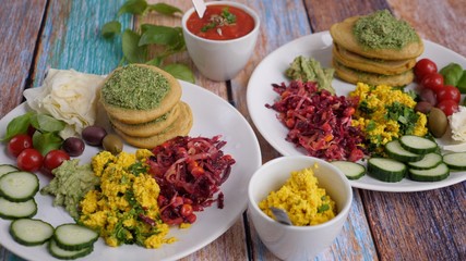 Healthy organic vegan breakfast for two served on white plates. Wooden table background.