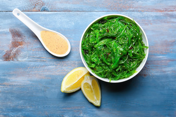 Bowl with tasty seaweed salad on table