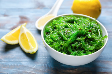 Bowl with tasty seaweed salad on table