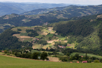 Fototapeta na wymiar View on mountains, meadow, hills and small village houses and dam in Tara national park in Serbia
