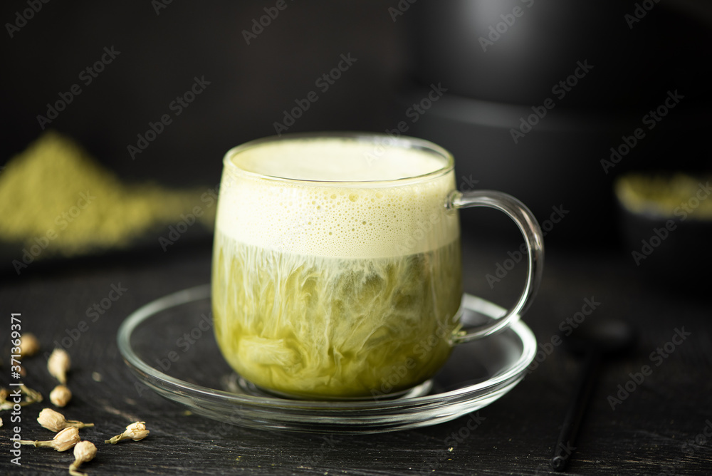 Wall mural green matcha with milk in a glass cup