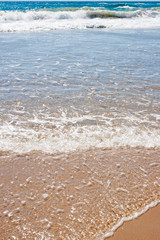 A sandy beach with soft ocean waves
