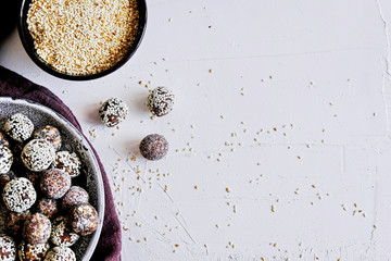 Obraz na płótnie Canvas Energy balls are prepared from dried fruits, granules, honey, sesame, cocoa, nuts.Healthy vegetarian treat. Healthy food, easy to make. White background. Top view. Homemade nut candies