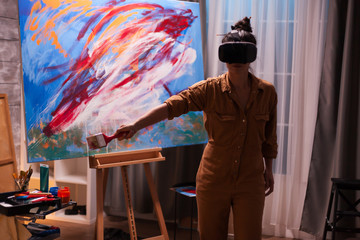 Creative artist ainting on virtual reality canvas wearing vr headset. Modern artwork paint on canvas, creative, contemporary and successful fine art artist drawing masterpiece