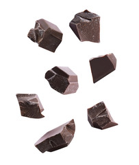 Pieces of delicious dark chocolate falling on white background