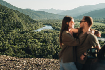 Naklejka premium Young Traveler Couple on a Road Trip, Man and Woman Enjoying Journey on Their Car Over Beautiful Landscape