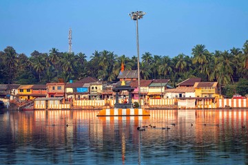 27.12.2019 Gokarna, Karnataka, Colorful indian houses, bright orange-striped temple tank on the...