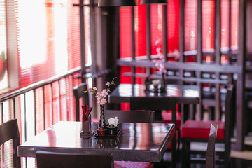 cope space in the interior and of restaurant in dark colors, flowers in Asian style are on the table