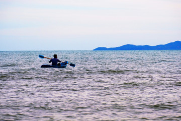 A man rolls a boat in the sea  to a far island