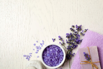 Cosmetic products and lavender flowers on white wooden background, flat lay. Space for text