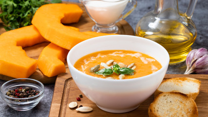 Pumpkin cream soup with seeds on a stone background, with copy space
