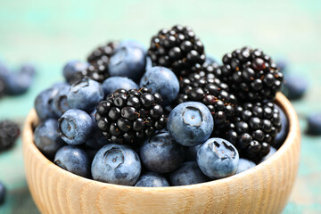 Blueberries and blackberries wooden in bowl, closeup
