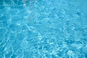 Texture of blue water in swimming pool as background, closeup