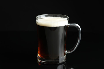 Glass mug of delicious kvass on black background