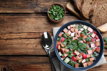 Delicious cold okroshka with kvass served on wooden table, flat lay and space for text. Traditional Russian summer soup