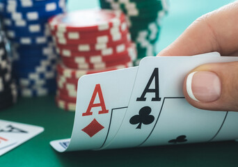 Pair of aces with chips stacks on a poker table