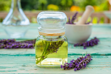 Homemade lavender flower oil on a wooden table.