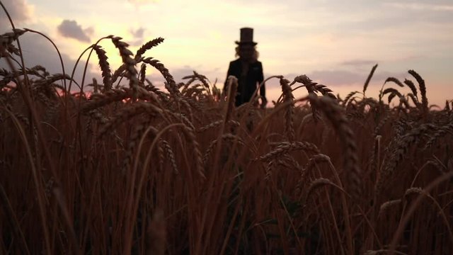 Man in image of revived dead walks through wheat field at sunset.