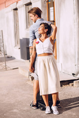 Naklejka premium Woman and man standing back to back near building