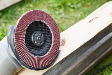 The electric wood sander lies on a smooth board.