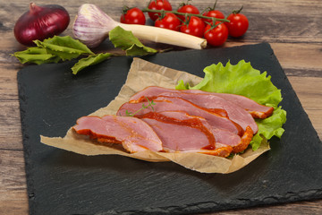Sliced smoked duck breast served salad