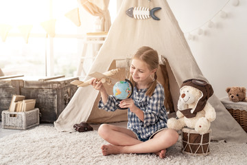 Smiling little girl playing with plane and globe, travel concept © Ievgen Skrypko