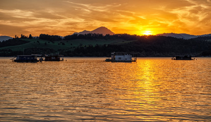 Fototapeta na wymiar Colorful sunset and reflection on water surface at lake Liptovska Mara, Slovakia.